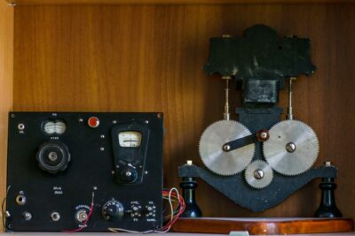 Close-up of vintage electrical equipment with metal gears in a wooden setting.
